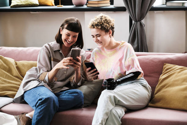 Two girlfriends using mobile phone stock photo