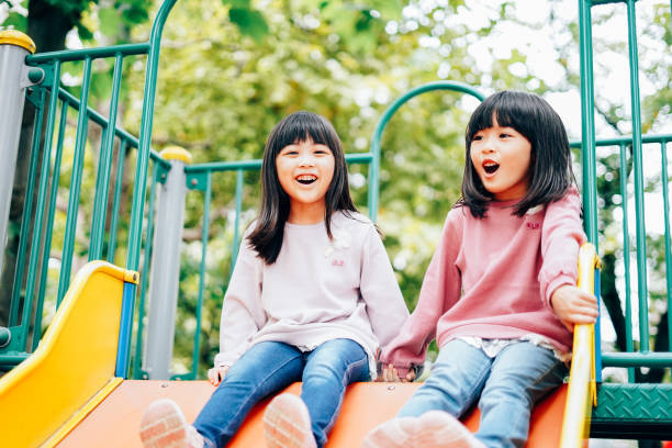 Two girls playing happily in the park Two girls playing happily in the park child korea little girls korean ethnicity stock pictures, royalty-free photos & images