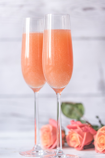 Two Glasses Of Bellini Cocktail With Bouquet Of Roses Stock Photo - Download Image Now - iStock
