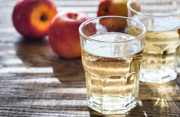 Two glasses of cider on the wooden background stock photo
