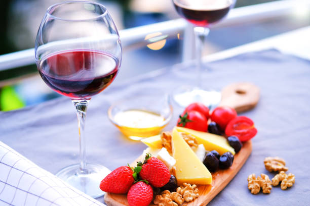 Two glasses of wine and cheese plate. Aperitif. stock photo