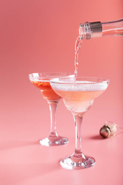 Two glasses with sparkling rose wine on pink background stock photo