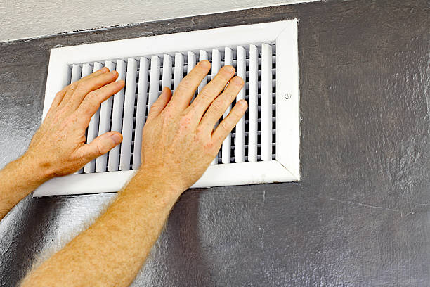 Two Hands in Front of an Air Vent stock photo