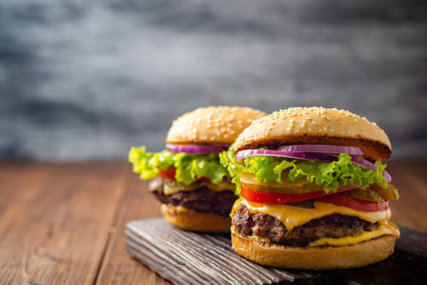 Two homemade tasty burgers on wood table stock photo