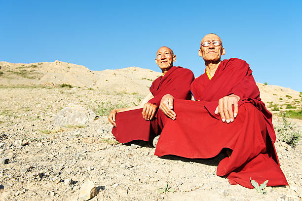 Two Indian tibetan monk lama Two Indian tibetan old monks lama in red color clothing sitting in front of mountains tibetan ethnicity stock pictures, royalty-free photos & images