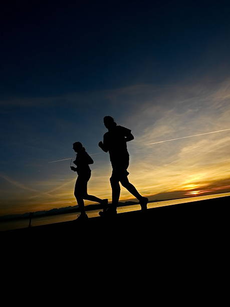 Woman and men running during sunset