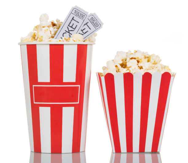 Two large striped boxes filled with popcorn, movie tickets on white. stock photo