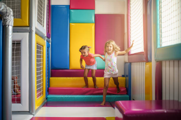 Two little girls in playground. Caucasian girls playing together. Two little girls in playground. Caucasian girls playing together. indoor playground stock pictures, royalty-free photos & images