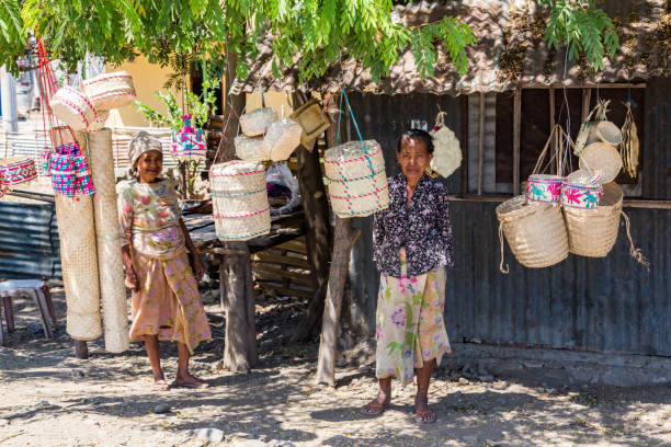 Two local elderly native East Timorese women, street vending traditional wicker baskets, near Dili, Timor-Leste. stock photo