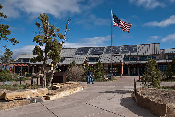Two Men Walk in Front of Grand Canyon Visitor Center Grand Canyon National Park, Arizona, USA - May 17, 2011: Two men are walking in front of the Grand Canyon Visitor Center at Mather Point. jeff goulden government building stock pictures, royalty-free photos & images
