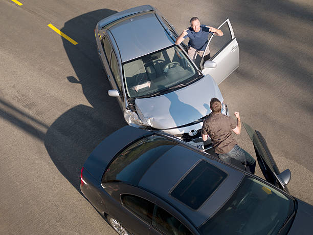 two men arguing about damage in car collision - auto ongeluk stockfoto's en -beelden