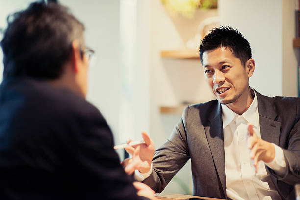 two men in a casual meeting in a cafe - japanse etniciteit stockfoto's en -beelden