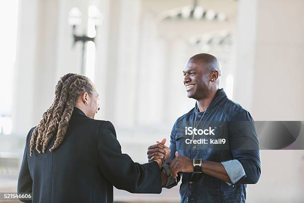 Two mixed race black men meeting, shaking hands