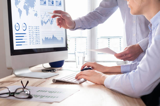 Two people analyzing stock market investment strategy on computer Two people analyzing stock market investment strategy with key performance indicator on financial dashboard and business intelligence on computer chart photos stock pictures, royalty-free photos & images