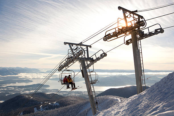 Two people riding a chairlift at Scweitzer Mountain Resort stock photo