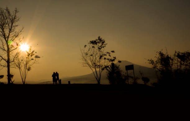 Two people silhouette on the sunset stock photo