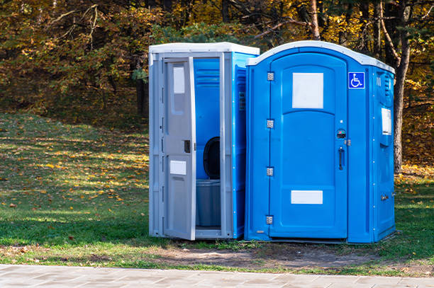 Two portable toilets in a park stock photo