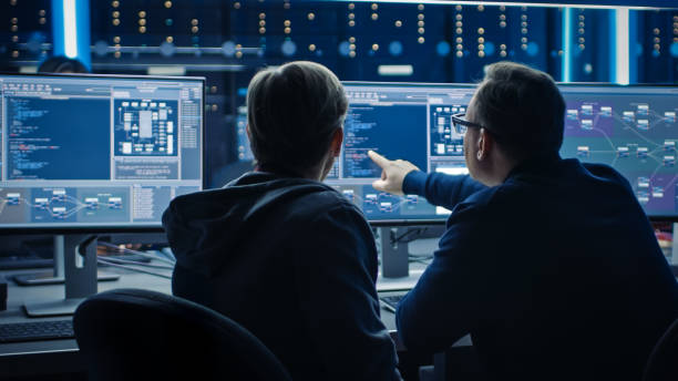 兩位專業 it 程式設計員討論桌上型電腦顯示幕上顯示的區塊鏈資料網路架構設計和開發。帶伺服器機架的工作資料中心技術部門 - cyber security 個照片及圖片檔
