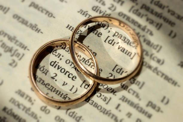 Two separate wedding rings next to the word "divorce". The concept of divorce, parting, infidelity . Selective focus. Two separate wedding rings next to the word "divorce". The concept of divorce, parting, infidelity . Selective focus. divorce stock pictures, royalty-free photos & images