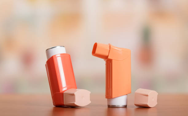 Two small pocket inhaler to relieve an asthma attack, on table stock photo