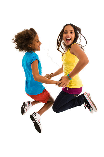 Two teenage girls jumping mid air making a face stock photo
