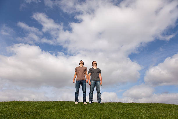 Two teenagers in the park looking at the sky stock photo