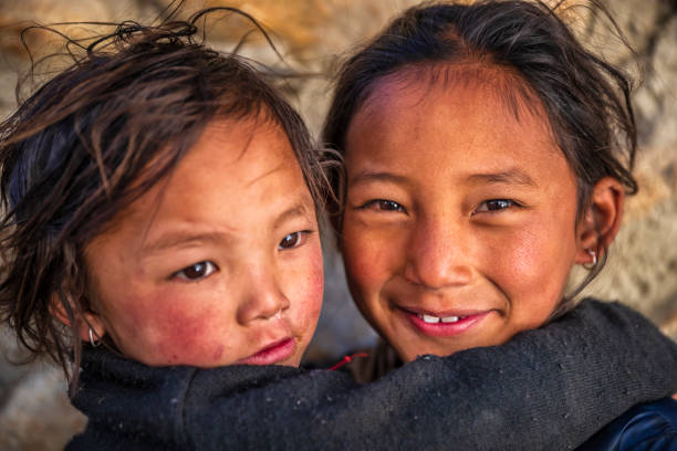 Two Tibetan young girls, Upper Mustang, Nepal Two Tibetan young girls from Lo Manthang, Upper Mustang. Mustang region is the former Kingdom of Lo and now part of Nepal,  in the north-central part of that country, bordering the People's Republic of China on the Tibetan plateau between the Nepalese provinces of Dolpo and Manang. tibetan ethnicity stock pictures, royalty-free photos & images