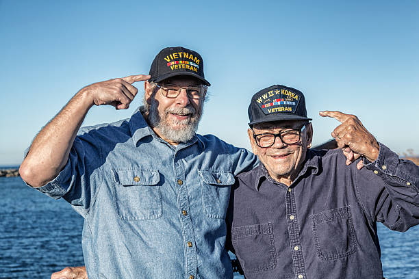 Two USA Military War Veterans Pointing At Souvenir Hats stock photo