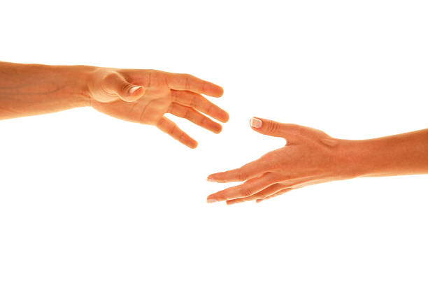 Two white people reaching their hands out to each other stock photo
