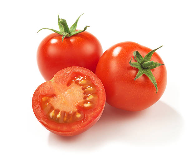 Two whole red ripe tomatoes and one in half stock photo