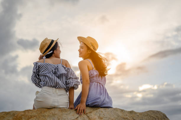 Two woman stay back to camera at  beautiful sunset on the beach. Two woman stay back to camera at  beautiful sunset on the beach. exotic asian girls stock pictures, royalty-free photos & images