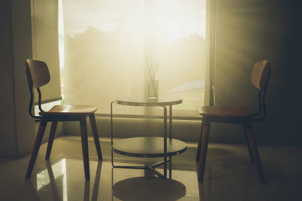 Two wood chair in dark room with sunlight in the morning stock photo