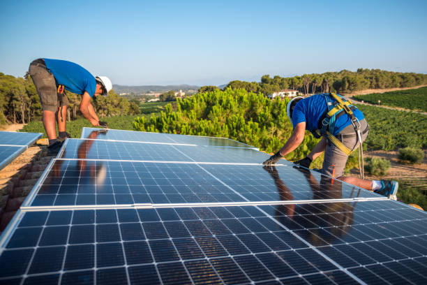 Two workers installing solar panels stock photo