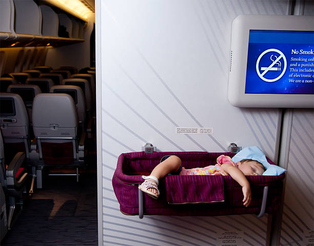 Two year old baby girl sleep in bassinet on airplane stock photo