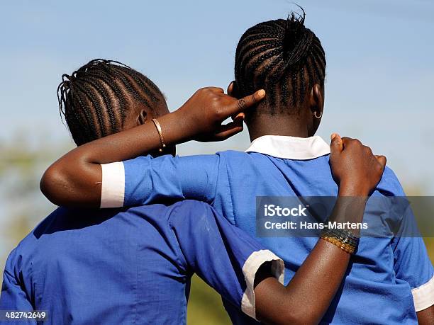 Two young african school girls showing frienship