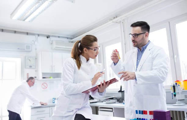 Two young doctors talking and discussing in laboratory stock photo