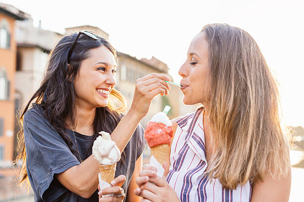 Two young friends eating ice cream in Florence stock photo