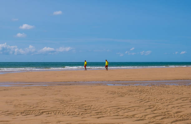 Two young men on the empty Beach of Barneville-Carteret, Normandy, France Normandy, France - August 25, 2018: Two young men on the empty Beach of Barneville-Carteret, Normandy, France barneville carteret photos stock pictures, royalty-free photos & images