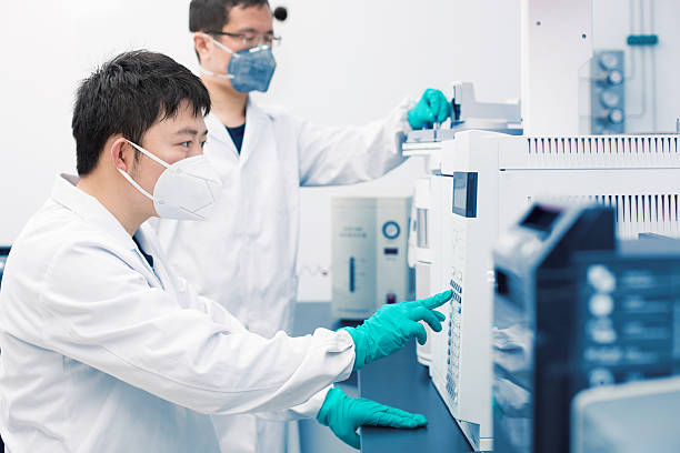 Two young researchers carrying out experiments in a lab stock photo