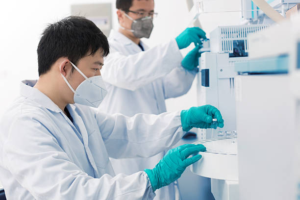 Two young researchers carrying out experiments in a lab stock photo
