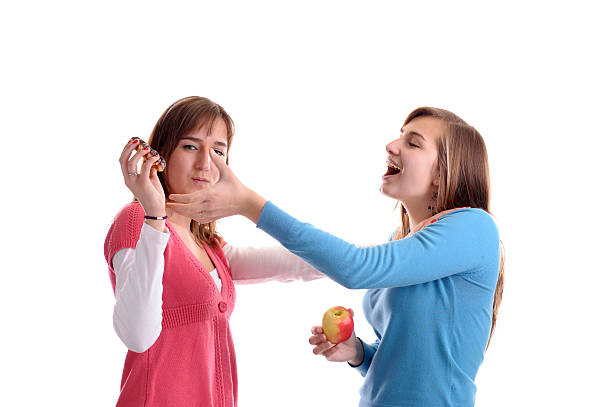 two young woman fighting for a  wafel stock photo