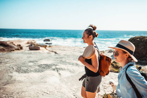 Two young women enjoying a sunny day in nature Two young women enjoying a sunny day on the beach beach hike stock pictures, royalty-free photos & images