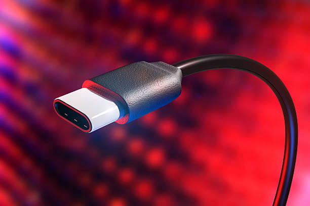 USB type C plug and cable, USB-C connection detail Conceptual rendering of a USB type C connection cable with detail of plug. USB-C allows faster data transfers, video communication and battery charging all in one compact plug. Red and blue abstract electronic background. usb cable stock pictures, royalty-free photos & images