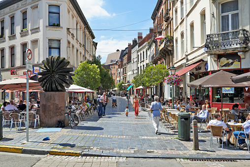 Brussels, Belgium - July 16, 2014: Some people take a break at lunch time on the Square Place Jourdan at Etterbeek near European Commission and EU-district in Brussels. Typical daily lunch time scene in Brussels. At this places are several restaurants and bars.