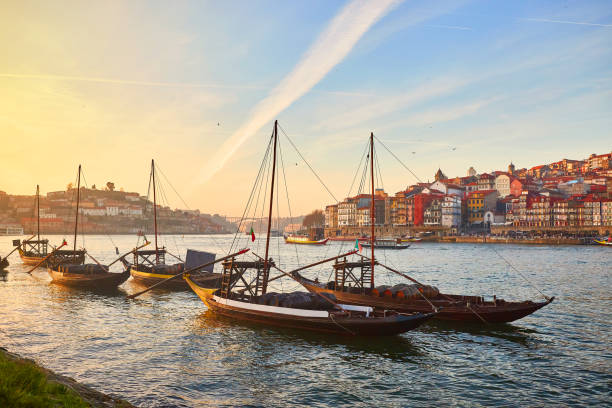 Typical portuguese wooden boats, called "barcos rabelos" transporting wine barrels on the river Douro with view on Villa Nova de Gaia  in Porto, Portugal stock photo