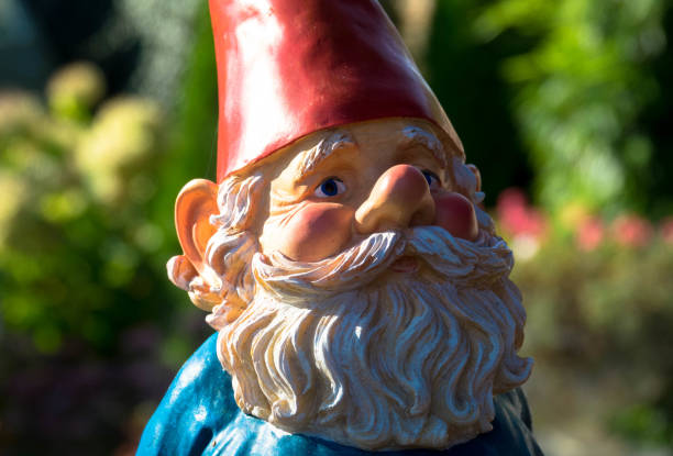 A typical traditional colorful German garden goblin with red hat and gray beard. stock photo