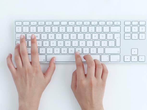 typing on keyboard. Female hands typing on a white computer keyboard. White background. computer keyboard stock pictures, royalty-free photos & images