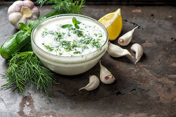 Tzatziki sauce ingredients cucumber garlic Healthy food background Tzatziki sauce with ingredients cucumber, garlic, dill, lemon, mint. Healthy food background dill stock pictures, royalty-free photos & images