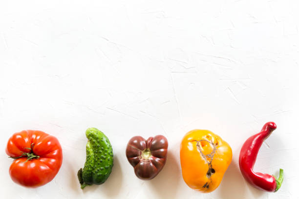 lelijke organische kleurrijke tomaat, peper, komkommer op witte concrete lijst. - onvolkomenheid stockfoto's en -beelden