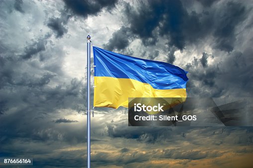 istock Ukraine flag. Ukrainian flag on black storm cloud sky. stormy weather 876656164